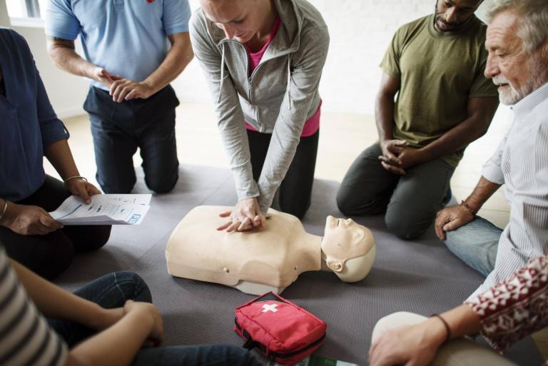 A class practicing CPR on a mannequin.